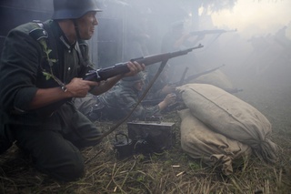  
History enthusiasts re-enact a World War II battle scene. ©REUTERS/Ints Kalnins