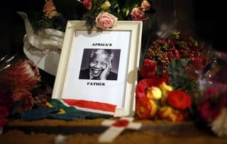 Flowers and tributes are left on the Nelson Mandela statue on Parliament Square in London December 6, 2013. ©Reuters/Suzanne Plunkett 