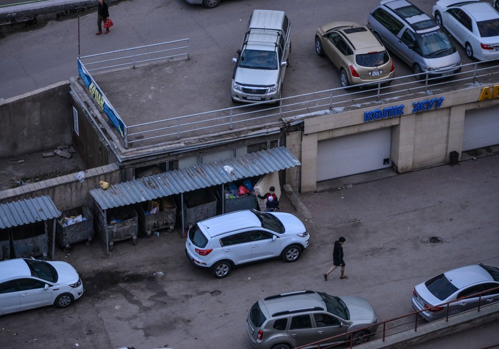 В отсутствии свободных мест авто паркуют возле мусорных контейнеров.
"Я как-то был свидетелем того, как автомобилями все контейнеры позакрывали. И рабочие никак не могли выкатить эти контейнеры. И знаете, что они начали делать? Они стали мусор пакетами оттуда перетаскивать в свою машину. Вот так, вручную, разгребать то, что там есть, и нести в мусоровоз, в XXI веке!" - возмущается молодой человек. Фото Турар Казангапов©