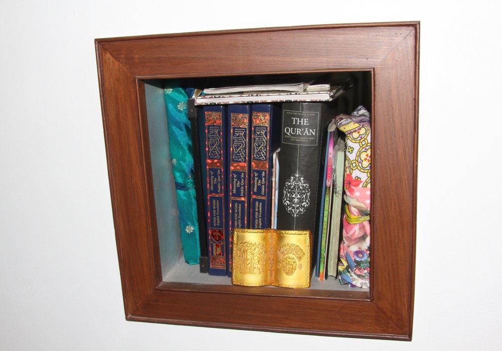 И Коран на книжной полке.