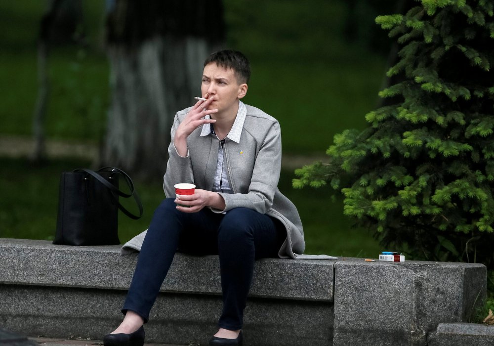 <p>Украинская летчица Надежда Савченко пьет кофе на ступеньках Верховной Рады перед первым заседанием после ее передачи российскими военными украинской стороне. Фото REUTERS/Gleb Garanich</p>