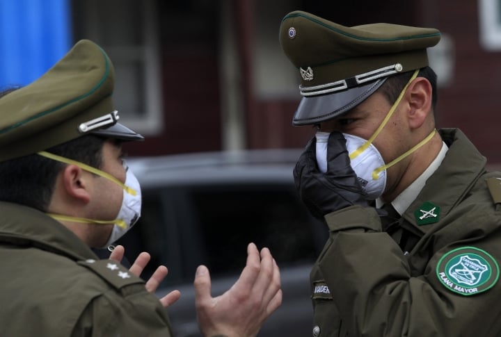 Чилийские полицейские, как и многие другие жители, снабжены масками. ©REUTERS/Ivan Alvarado