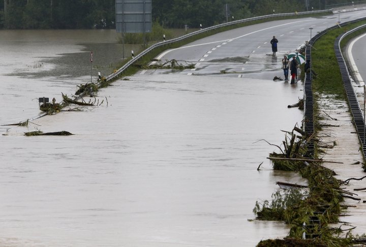 Люди смотрят на затопленное шоссе A8, которое идет из Мюнхена в Зальцбург. Фото ©REUTERS