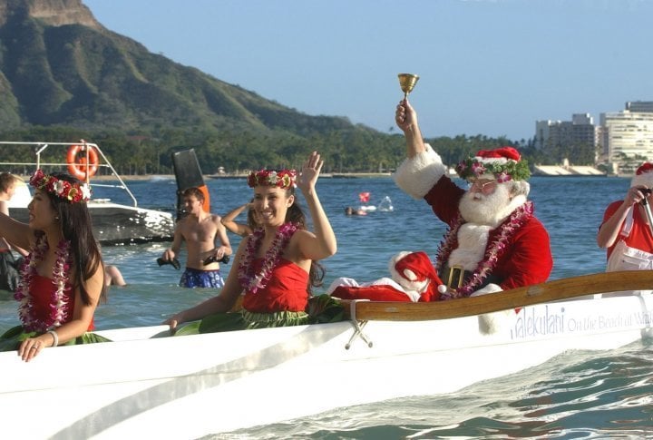 Santa Claus, aka Gene DiCicco, makes a big splash as he arrives on Waikiki Beach, Honolulu. ©Reuters/Lucy Pemoni