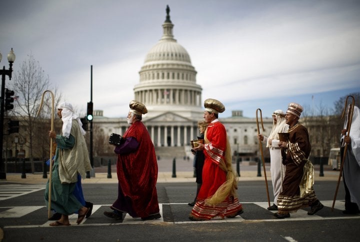 Actors dressed as (L-R) Joseph and the Three Wise Men, part of a live-human nativity scene, stroll past the U.S. Capitol Building after demonstrating outside the nearby Supreme Court in Washington. ©Reuters/Jason Reed