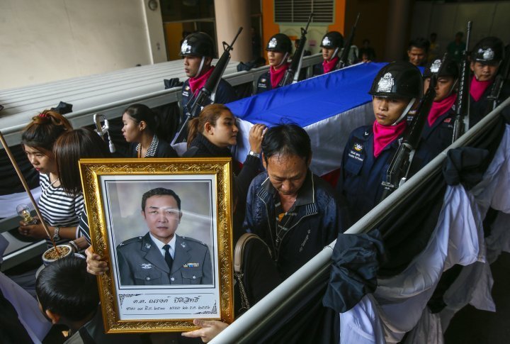 Relatives and mourners lead a procession to a temple for the funeral ceremony of Narong Pitisitthi, 45, a policeman who died after being shot during the clashes between anti-government protesters and riot police. ©Reuters