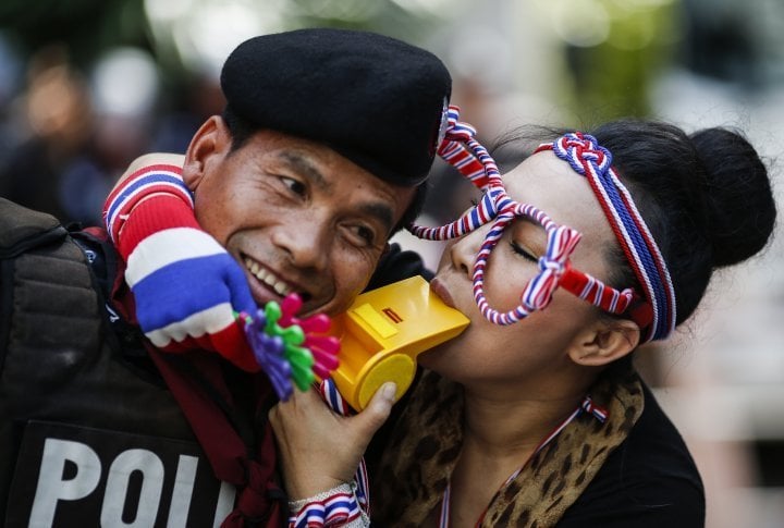 A demonstrator blowing a whistle, hugging the policeman. ©Reuters