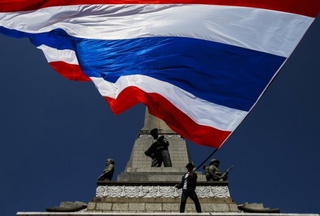 Anti-government protesters wave Thai national flags as they gather with others at Victory monument in central Bangkok. ©Reuters