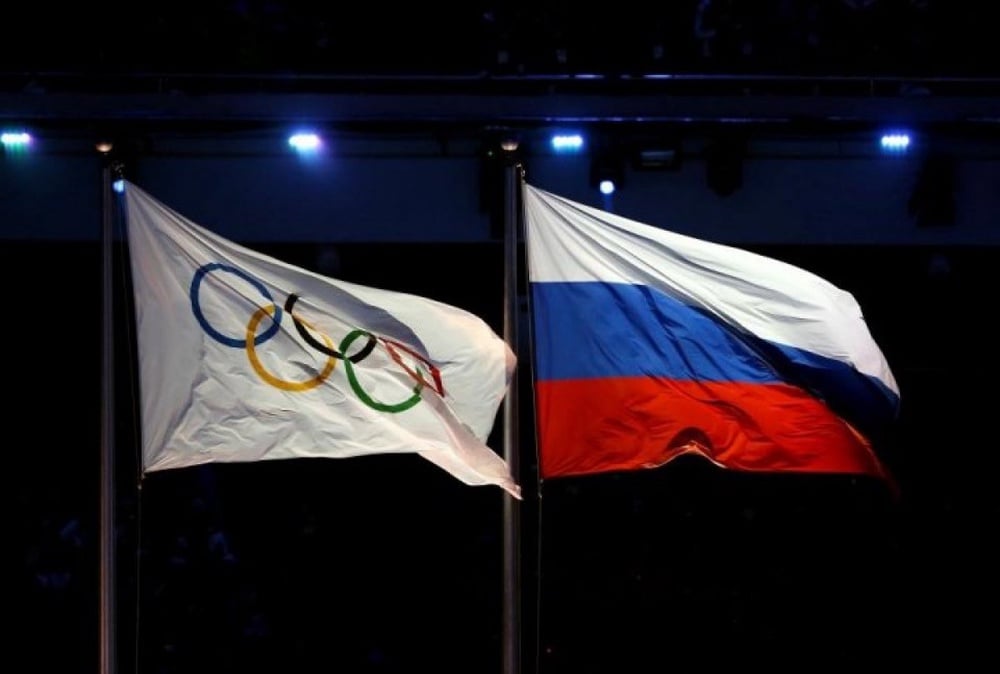 The Olympic flag (L) and the Russian flag are hoisted during the Opening Ceremony of the Sochi Winter Olympics. ©sochi2014.com