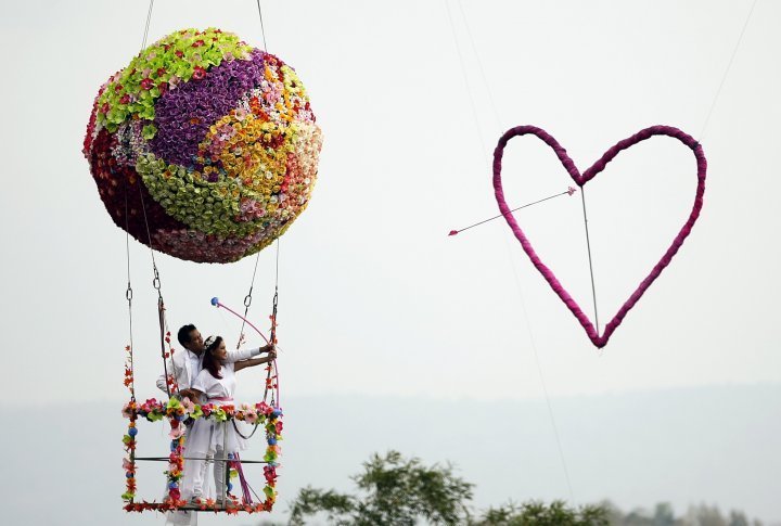 A bride and groom shoot an arrow from a bow during the wedding ceremony on the Valentines Day eve in Thailand. ©Reueters