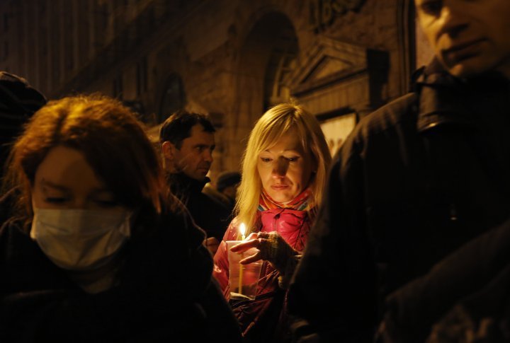 A woman, holding a candle, took part in transporting more than a dozen dead bodies from the hotel lobby to the local hospital after clashes at the Independence Square. ©Reuters