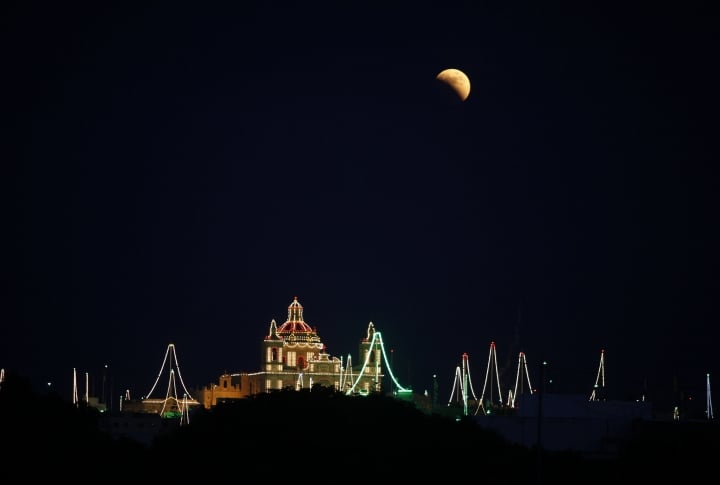 Lunar eclipse close to Zejtun village at the background of church of St Catherine in Malta. ©REUTERS/Darrin Zammit Lupi