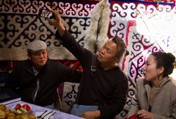 Korean guest taking pictures of the interior of Kazakh national house. <br>Photo by Vladimir Dmitriyev©