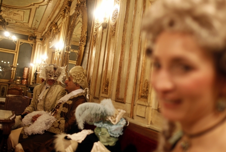 Masked revellers stand inside Caffe' Florian coffee shop in Saint Mark's Square during the Venetian Carnival in Venice . ©REUTERS/Tony Gentile