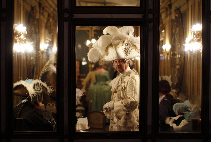 Masked revellers stand inside Caffe' Florian coffee shop in Saint Mark's Square during the Venetian Carnival in Venice . ©REUTERS/Tony Gentile