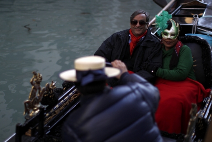 Masked tourist have their picture taken by a gondolier near Saint Mark's Square during the Venetian Carnival in Venice. ©REUTERS/Tony Gentile