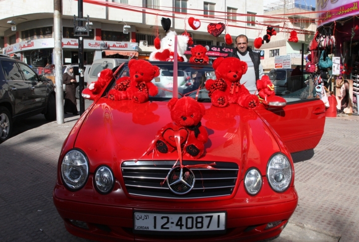 A man stands next to his car decorated with teddy bears and displayed next to his shop selling Valentine's Day gifts at the popular Jabal Al Hashmi square. ©REUTERS/Majed Jaber