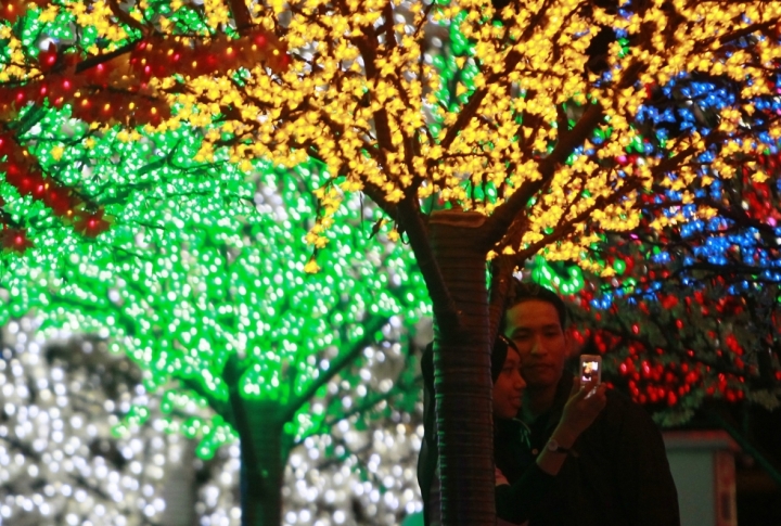 A Muslim couple takes pictures at the "Million Lights, Million Hearts" display ahead of Valentines Day celebrations at Shah Alam commercial hub i-City, outside Kuala Lumpur. ©REUTERS