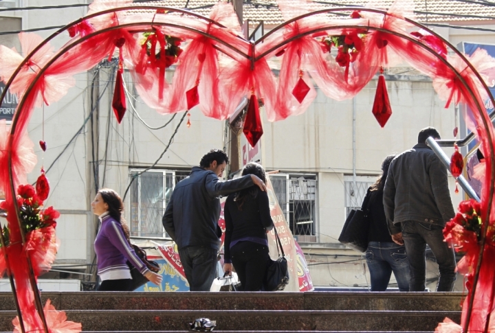 People walk past a decoration in the shape of a heart displayed ahead of Valentines Day at the port city of Sidon, southern Lebanon. ©REUTERS/Ali Hashisho