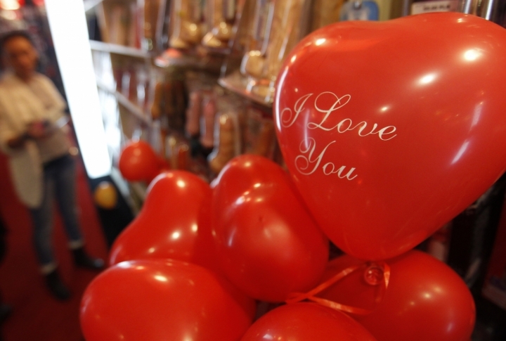 A salesperson shows items at a sex shop on the eve of Valentines Day in Warsaw. ©REUTERS/Peter Andrews