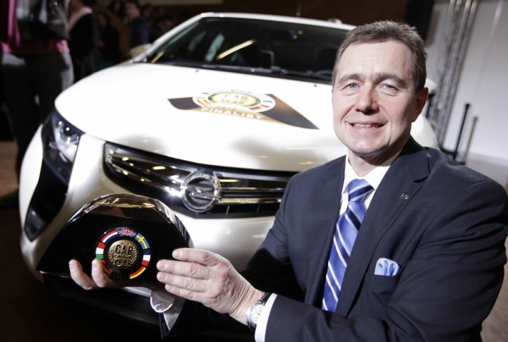 Director General of Adam Opel AG posing with the Car of the Year 2012 prize next to Opel Ampera. ©REUTERS