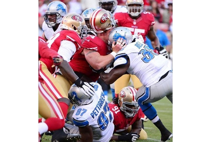 49ers defensive tackle Justin Smith loses his helmet trying to tackle running back Joique Bell of the Lions. Photo courtesy of SI.com