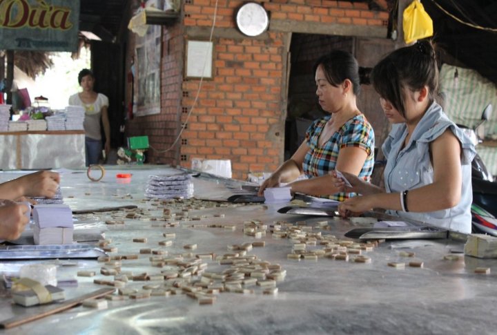 Coconut island. Local citizen are making coconut candies with peanuts and fruits. Photo by Roza Yessenkulova©