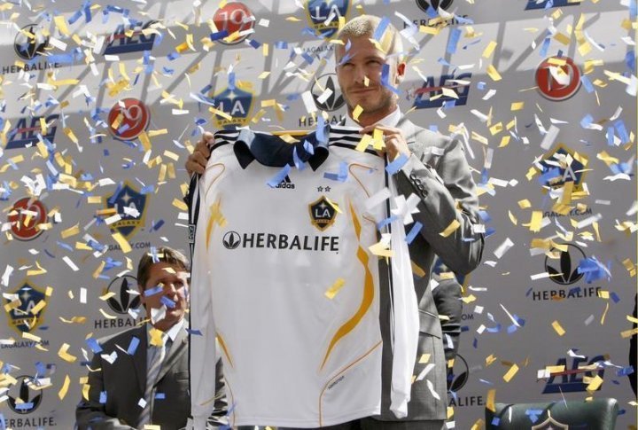 Britain's David Beckham smiles as he holds his new team jersey during an LA Galaxy news conference introducing him as the newest member of the MLS soccer league team. ©REUTERS/Toby Melville