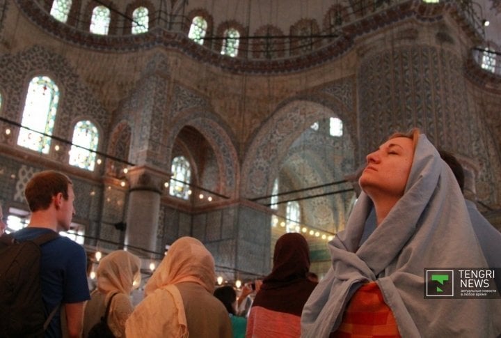 At the entrance women are given veils to cover their heads and bodies. Photo by Vladimir Prokopenko©