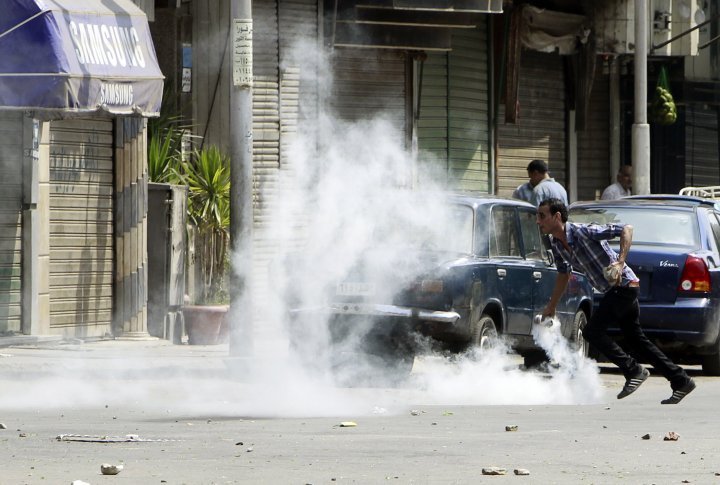 A supporter of ousted Egyptian President Mohamed Mursi throws a tear gas canister back towards police during clashes in central Cairo August 13, 2013. ©REUTERS