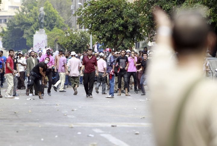 A local resident (foreground, on R) gestures towards supporters of ousted Egyptian President Mohamed Mursi during clashes in central Cairo August 13, 2013. ©REUTERS