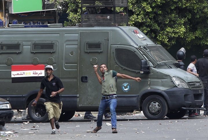 A local resident throws stones towards supporters of ousted President Mohamed Mursi during clashes in central Cairo August 13, 2013. ©REUTERS