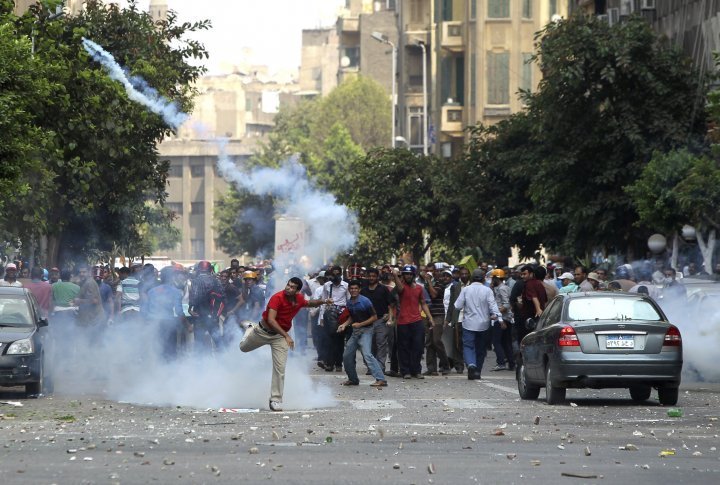 A supporter of ousted President Mohamed Mursi throws a tear gas canister back towards the police during clashes in central Cairo August 13, 2013. ©REUTERS