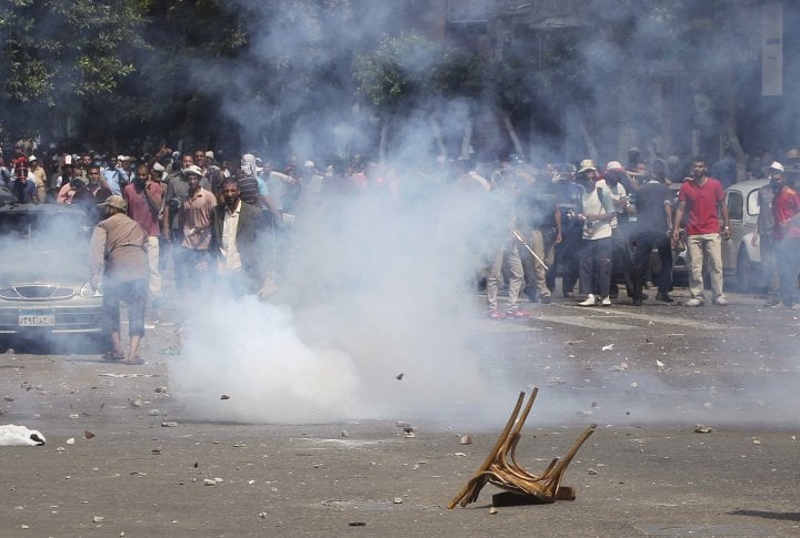 A chair is seen on the ground as supporters of ousted Egyptian President Mohamed Mursi move back from tear gas thrown by police during clashes in central Cairo August 13, 2013. ©REUTERS