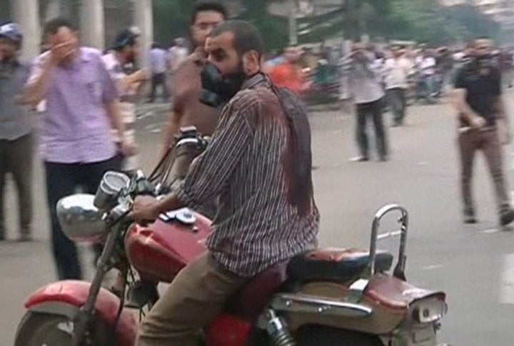 A man wearing a gas mask rides a motorcycle while wearing a blood-drenched shirt as security forces break up the protest camp at al-Nahda square in Cairo August 14, 2013. ©REUTERS