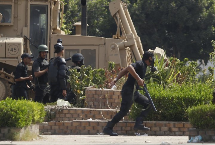 A riot police officer runs during clashes with members of the Muslim Brotherhood and supporters of deposed Egyptian President Mohamed Mursi. ©REUTERS