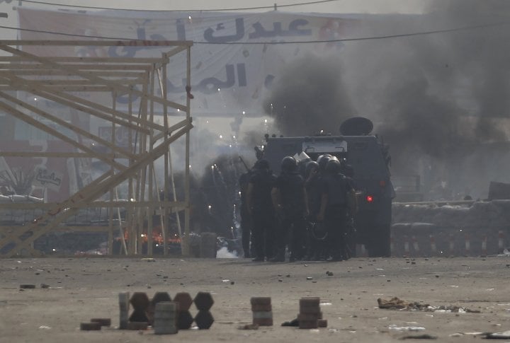 Riot police gather behind an armoured vehicle. ©REUTERS