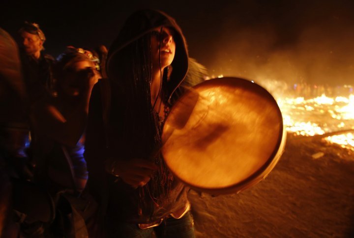 A participant makes her way around the flames as the Temple of Whollyness is burned. ©REUTERS