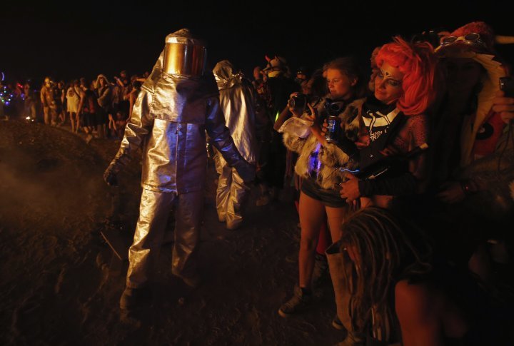 A firefighter keeps people from getting too close to the burnt remains of the Man. ©REUTERS