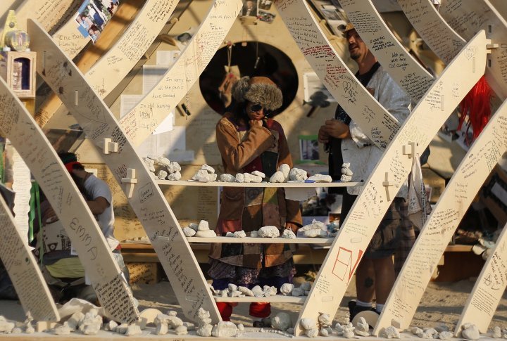 Rasika Mathur (L) and Grant Ball look at messages left by participants at sunrise at the Temple of Whollyness. ©REUTERS