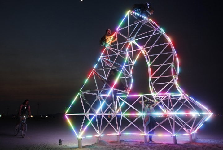 Participants climb an art installation before sunrise. ©REUTERS