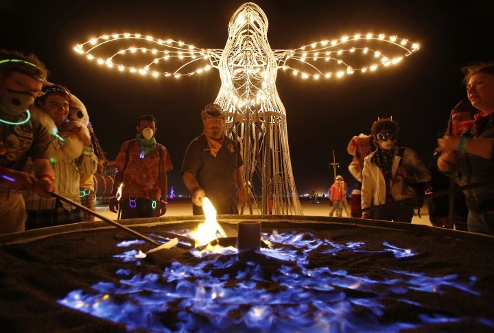 Christian Jacobsen (C) adjusts the sand at the Guardian of Dawn art installation. ©REUTERS