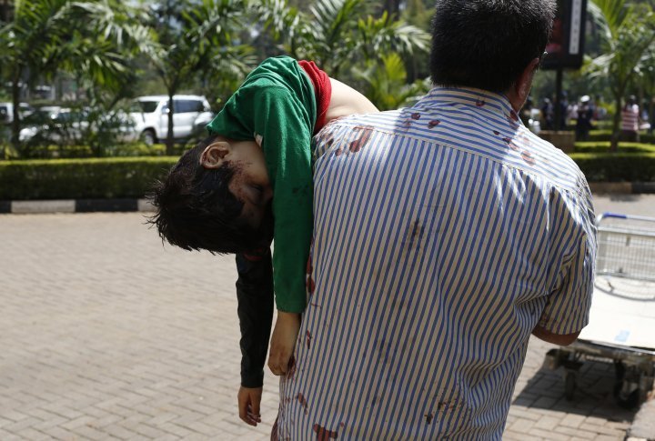 A man carrying a child out of the mall in Nairobi, September 21, 2013. ©REUTERS