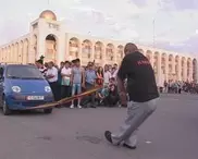 ФОТО: Кыргызский силач на коже локтей протащил пять машин 