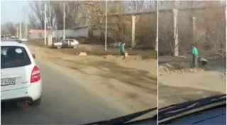 Дети засыпают ямы на дороге в Алматы