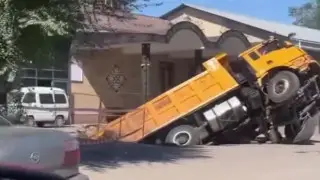 Грузовик ушёл в яму провалившегося асфальта близ Алматы: видео