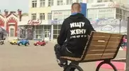 Kostanay citizen wears Looking for a Wife sign with phone number on his back