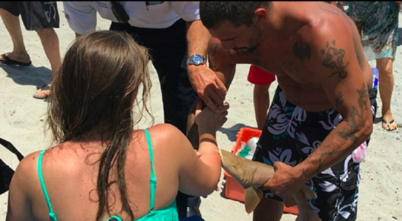 A woman with a shark clutching to her arm. Photo courtesy of Boca Raton Fire Rescue.