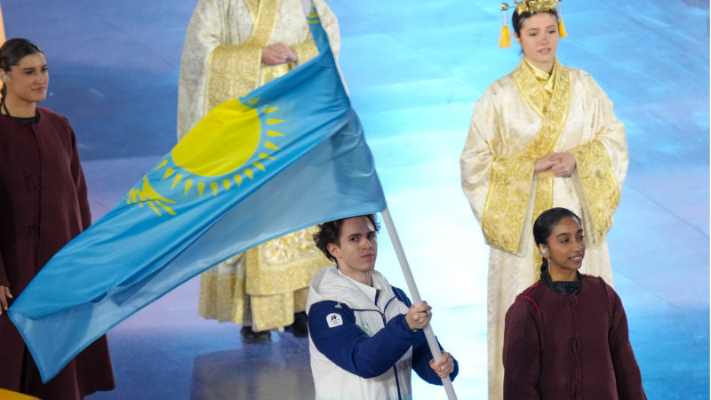 Mikhail Shaidorov carries the flag at the closing ceremony of the Milan Olympics. Photo by the NOC of Kazakhstan