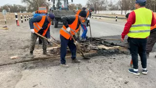Үштөбеде жол жөндеушілер теміржол рельсі үстінен асфальт төсеп тастаған